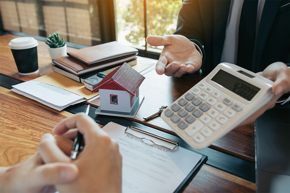 Agents are calculating the loan payment rate or the amount of insurance premiums for customers coming to contact the purchase of a new home at the office.
